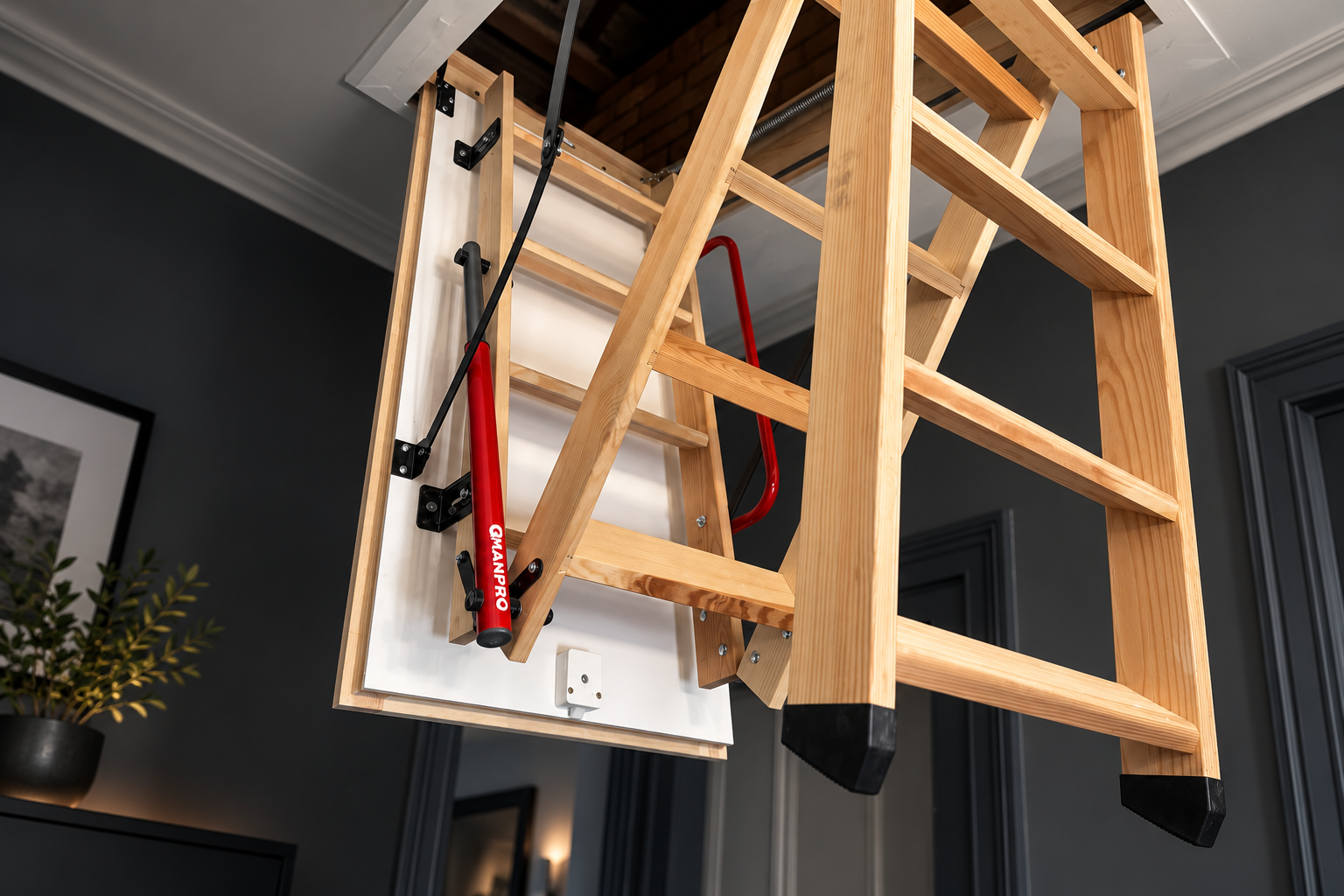 QMAN PRO red assist mechanism professionally fitted to a wooden folding loft ladder